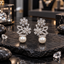 Silver-tone floral earrings with clear flower motifs, clear-accent open leaf details and round white pearl-look drops.