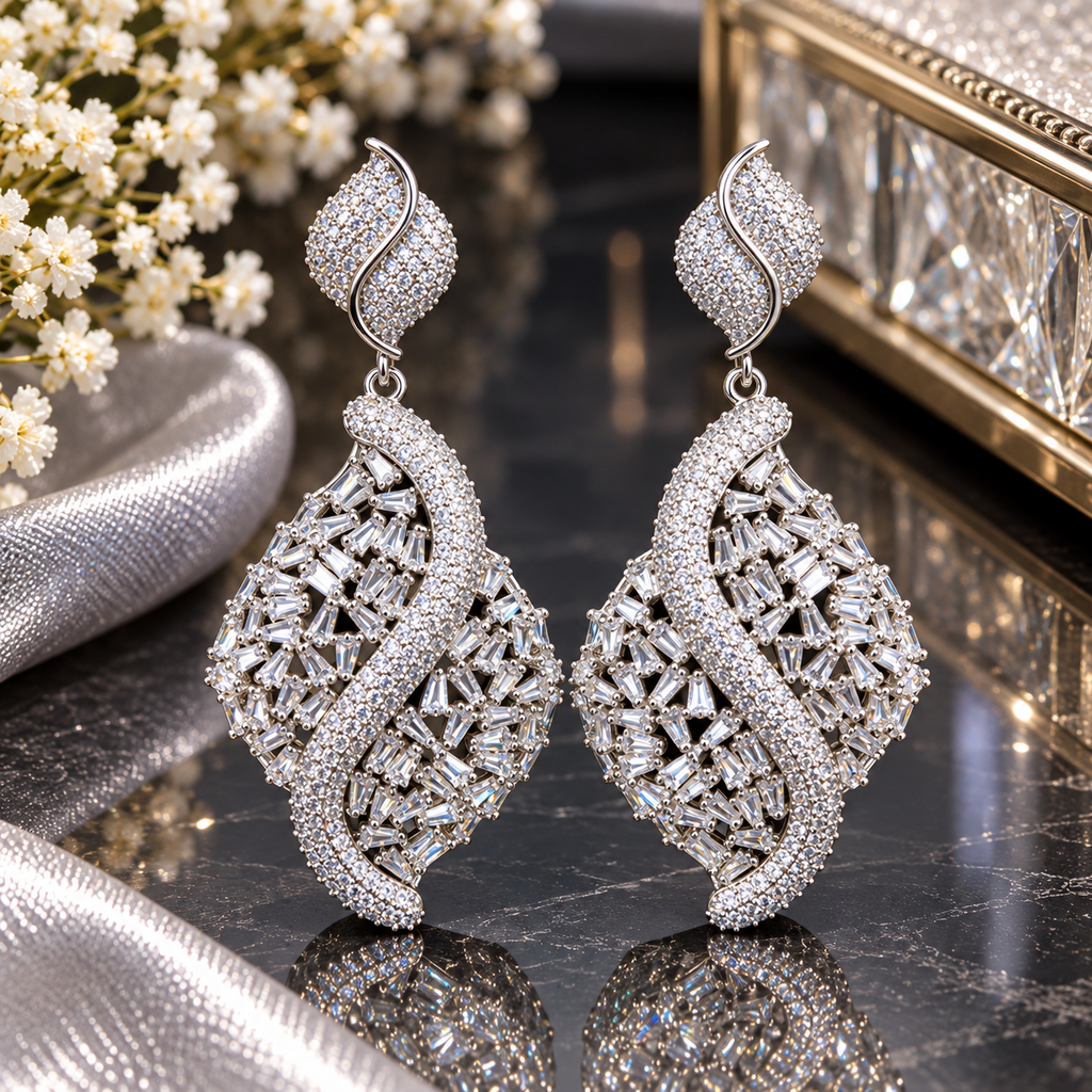 Silver-tone openwork drop earrings with leaf-like tops, tapered rectangular clear accents and sweeping S-shaped clear-accent bands.