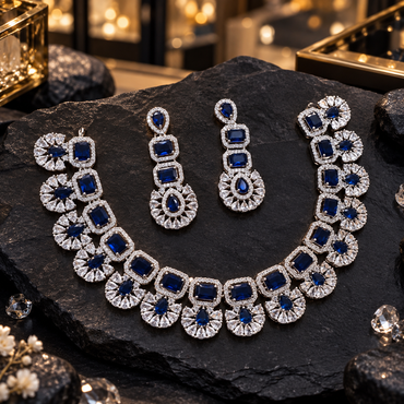 Silver-tone necklace and matching drop earrings with dark-blue rectangular and teardrop accents, clear borders and floral-style clear petal details.