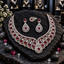Silver-tone scalloped necklace with deep-red oval centres, matching teardrop earrings and a separate matching teardrop-shaped piece.