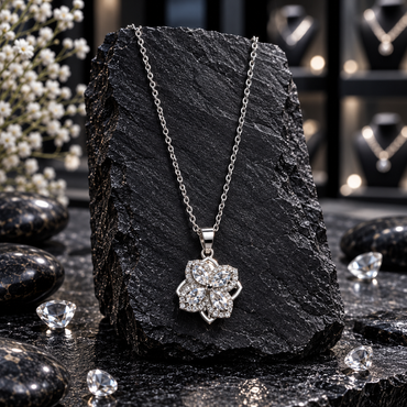Silver-tone link chain necklace with a four-petal spinner locket, marquise-shaped clear accents, small clear halo borders and an openwork flower outline.
