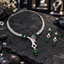 Silver-tone AD necklace and earrings set with clear leaf details, rectangular green accents, open geometric frames and clusters of three green teardrop drops.