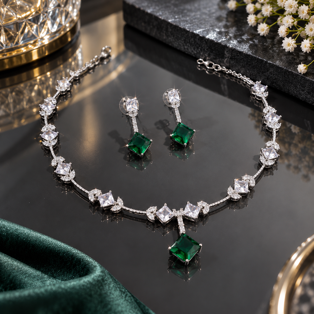 Silver-tone necklace and matching drop earrings with green square-shaped drops, clear square accents, and small leaf-like details.