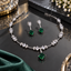 Silver-tone necklace and matching drop earrings with green square-shaped drops, clear square accents, and small leaf-like details.