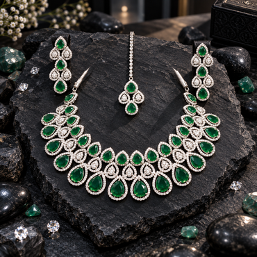 Silver-tone necklace with graduated green halo teardrops and clear-looking teardrop clusters, matching elongated earrings and a green chain bindia.