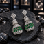 Pair of silver-tone tiered AD jhumka earrings with clear crown-like tops, sparkling upper bells and green teardrop rows on the lower domes.
