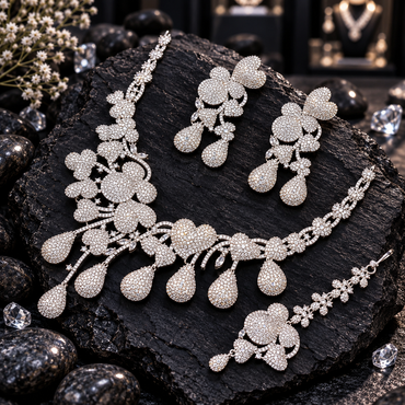 Silver-tone clear-accent necklace with heart and floral-inspired panels and cascading teardrops, matching double-drop earrings and floral-chain bindia.