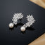 Silver-Tone Marquise CZ Feather Wing Pearl Drop Earrings product shot on black reflective surface