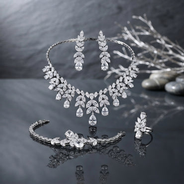 Silver-Tone Marquise and Pear CZ Leaf Spray 4-Piece Bridal Jewelry Set worn by model in black embroidered velvet bridal outfit in Mughal carved wooden arch setting showing full set with collar necklace drop earrings marquise CZ bracelet and cocktail ring in editorial bridal portrait