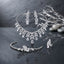 Silver-Tone Marquise and Pear CZ Leaf Spray 4-Piece Bridal Jewelry Set worn by model in black embroidered velvet bridal outfit in Mughal carved wooden arch setting showing full set with collar necklace drop earrings marquise CZ bracelet and cocktail ring in editorial bridal portrait