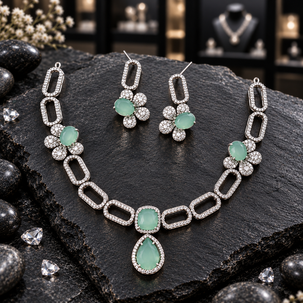 Silver-tone open rectangle-link necklace with mint green floral side motifs, a cushion-shaped centre and teardrop drop, alongside matching floral earrings.