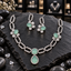 Silver-tone open rectangle-link necklace with mint green floral side motifs, a cushion-shaped centre and teardrop drop, alongside matching floral earrings.