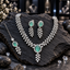 Silver-tone necklace with a mint-green oval halo centre, paired clear-looking leaf details and a descending sprig, with matching earrings and bindia.