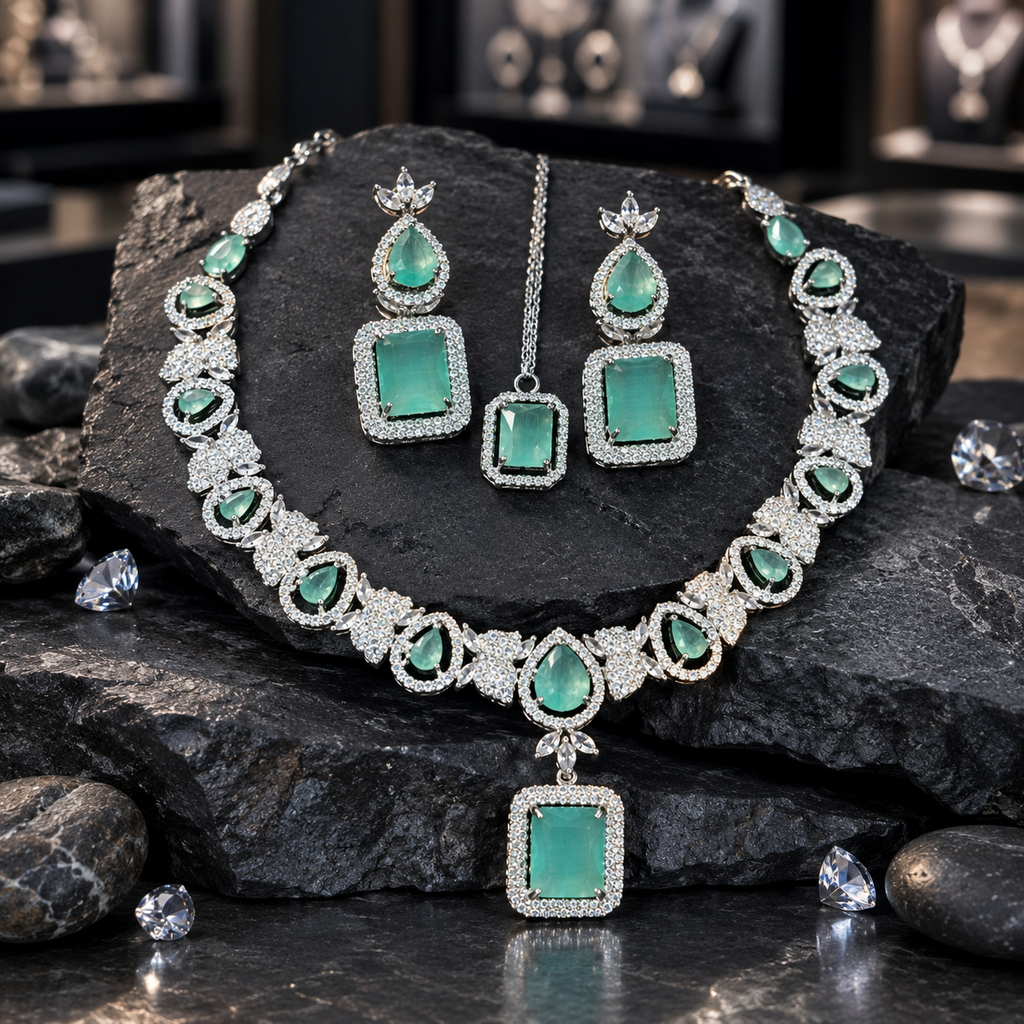 Silver-tone mint-green necklace with teardrop halo accents, clear leaf-inspired clusters and a rectangular centre drop, displayed with matching earrings and rectangular maang tikka on dark slate.
