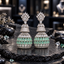 Pair of silver-tone tiered AD jhumka earrings with clear crown-like tops, sparkling upper bells and mint green teardrop rows on the lower domes.