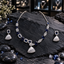 Silver-tone necklace with navy blue accents, asymmetric rectangle and open teardrop links, a clear-looking striped fan pendant and matching earrings.