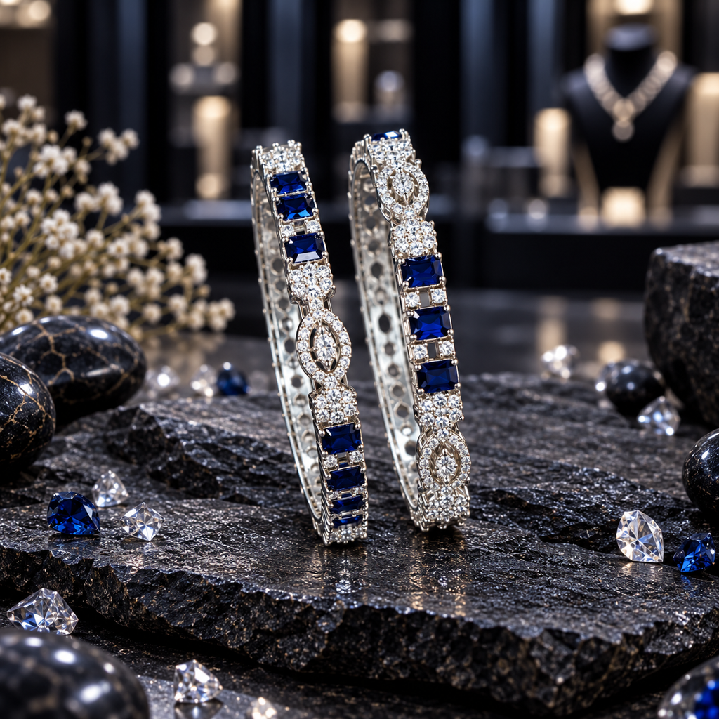 Two silver-tone AD-style bangles with grouped navy blue rectangular accents, clear-looking clusters and pointed oval decorative motifs.