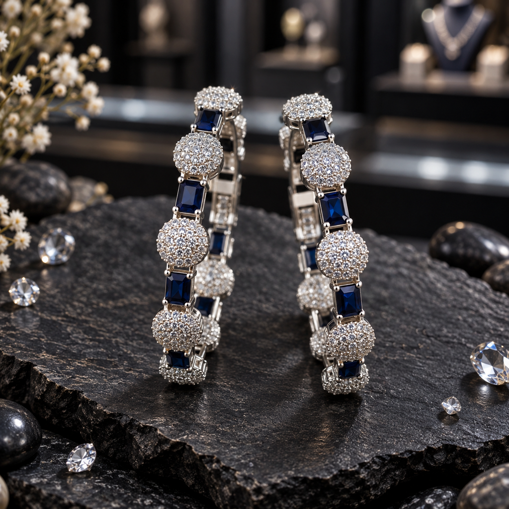 Two silver-tone AD-style bangles with alternating navy blue rectangular accents and raised round clusters of small clear-looking details.