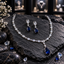 Silver-tone AD necklace and matching earrings with clear marquise and round accents, clear earring tops and navy blue teardrop drops.