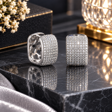 Pair of silver-tone rounded rectangular huggie hoop earrings with clear pavé-style accents and interior heart-shaped cutouts.