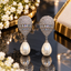 Silver-tone earrings with embellished tapered tops, two rectangular clear-accent bands and ivory-white teardrop pearl-look drops.