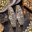 Pair of silver-tone openwork bangles with oval pink accents and clear faceted details.