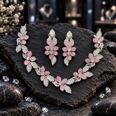 Silver-tone floral vine necklace with pink oval petals, clear-looking flower centres and decorative leaves, with matching elongated earrings.
