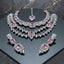 Silver-tone jewelry set with two necklaces, matching earrings, and maang tikka, accented with pink and clear faceted details.