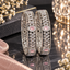 Pair of silver-tone openwork bangles with pink oval accents and clear faceted details.