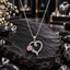 Silver-tone oval-link chain necklace with an open heart pendant, raised pink rose, two green leaf details and clear-looking accents.