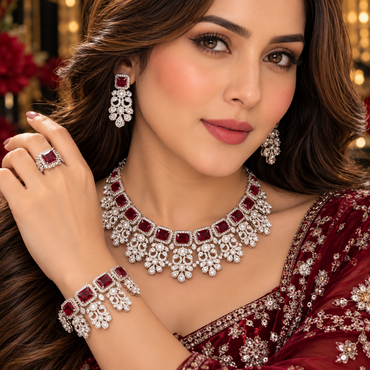 Model wearing a silver-tone red AD necklace, floral-style earrings, matching bracelet and rectangular red-centre ring.