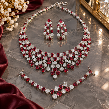 Silver-tone AD jewellery set with a red-accent fringe necklace, matching tiered earrings and bracelet displayed on marble.