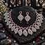 Silver-tone AD necklace with deep red oval halo centres and pointed openwork leaf fringe, with matching teardrop-finish earrings.