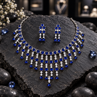 Silver-tone necklace with royal blue square accents, graduated clear-accent fringe and rounded blue drops, alongside matching twin-drop earrings.