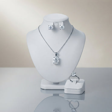 Silver-tone set displayed with a clear-stone pendant necklace, stud earrings, and matching ring.