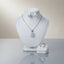 Silver-tone set displayed with a clear-stone pendant necklace, stud earrings, and matching ring.