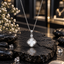 Silver-tone link chain necklace with a white iridescent-look clover pendant, curved decorative border and round clear accent above the clover.