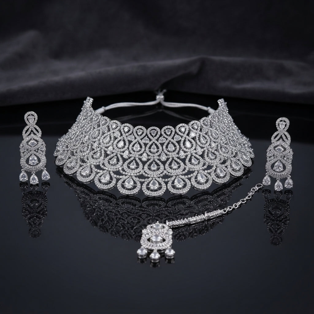 Silver White CZ Grand Pear Lattice Choker Necklace Earrings and Maang Tikka Bridal Set on dark mirror surface with satin backdrop showing rhodium silver wide micro-pave choker with pear lattice arches matching chandelier earrings and maang tikka