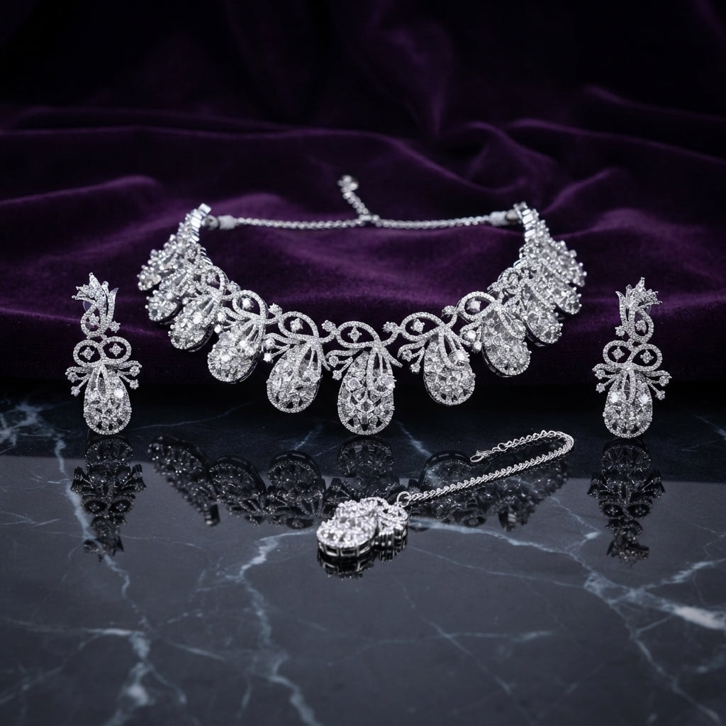 Silver White CZ Peacock Feather Filigree Choker Earrings and Maang Tikka Bridal Set flat lay on dark black marble with purple velvet backdrop showing 7 graduated peacock feather filigree teardrop motifs with scrolling vine white CZ and oval solitaire centres matching drop earrings and maang tikka