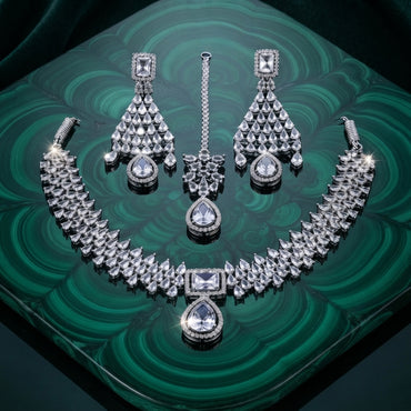 Silver White CZ Tiered Waterfall Pear Choker Necklace Earrings & Maang Tikka Bridal Set on green malachite tray with dark green velvet backdrop