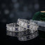 Silver-Tone Wide Art Deco Baguette & Oval Sapphire Blue CZ Openwork Geometric Micro-Pavé Bridal Bangle Set of 2 on black mirror surface with grey concrete stone prop and dark green velvet fan backdrop