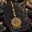 South Indian-style gold-tone bindia with pink and green accents, ornate openwork scroll details, floral upper links and five round pearl-look hanging drops.