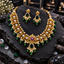 South Indian-style gold-tone necklace with clear oval accents, a deep-pink centre, green drops and cream-white pearl-look clusters, with matching earrings.