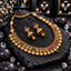South Indian-style gold-tone necklace with clear, deep pink and green oval accents, embossed coin-like fringe and matching dome jhumka earrings.