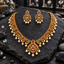 Gold-tone South Indian-style scroll necklace with pink and green accents, an openwork pendant and cream pearl-look fringe, alongside matching earrings.