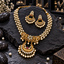 South Indian-style gold-tone three-row cream-white pearl-look necklace with a green-centred floral panel, pink-accent crescent pendant and matching earrings.