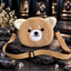 Front view of tan teddy-face crossbody bag with cream ears, white muzzle, pink tongue detail and adjustable tan strap.