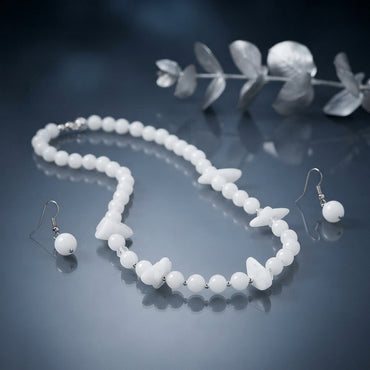 White round-bead necklace with petal-shaped accents and silver-tone spacers, displayed with matching white-bead drop earrings.